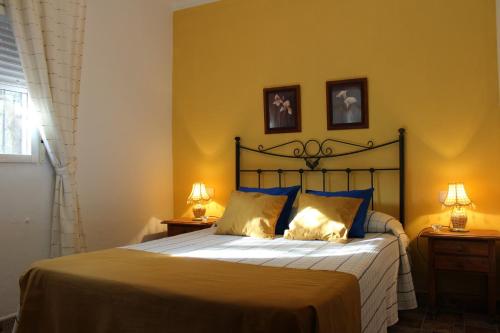 - une chambre avec un lit et 2 lampes sur 2 tables dans l'établissement El Llano de la Encina, à Antequera