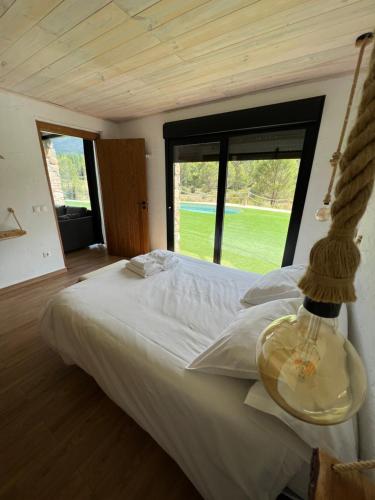 a bedroom with a large white bed with a large window at Casa rural Rio de Cotillas in Cotillas