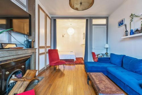 un salon avec un canapé bleu et une cheminée dans l'établissement Appartement Merisier - Welkeys, à Villeurbanne