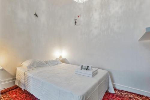 - un lit blanc dans une chambre dotée d'un mur blanc dans l'établissement Appartement Merisier - Welkeys, à Villeurbanne