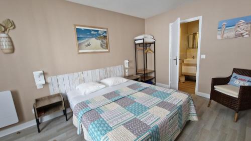 een slaapkamer met een bed en een stoel erin bij Hotel Vent d'Ouest in Fécamp