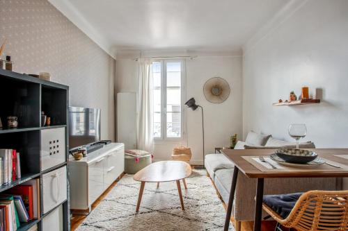 布洛涅－比揚古的住宿－Charming 1br in the center of Boulogne Billancourt - Welkeys，一间带桌子和沙发的客厅以及一间厨房。