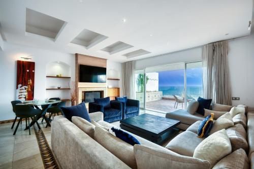 - un salon avec un grand canapé et une table dans l'établissement Mauritania - Luxe - ocean view for 4 or 5 Px, à Agadir