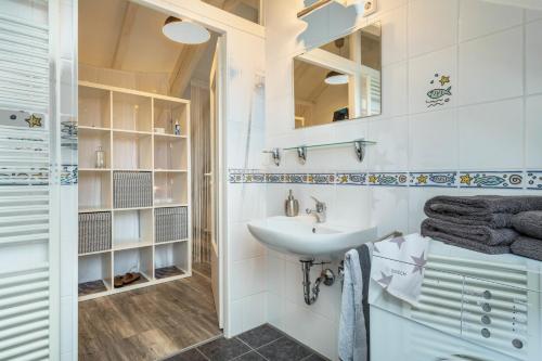 uma casa de banho branca com um lavatório e um espelho em Straub em Meckenbeuren