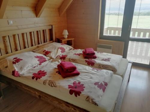 Un dormitorio con una cama blanca con flores. en Chaty Rybárska Osada en Liptovská Sielnica