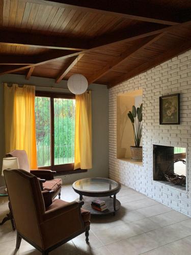 a living room with a coffee table and a fireplace at Casa en Barrio el Golf in Alta Gracia