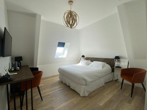 a bedroom with a bed and a table and a desk at LA TOUR AUX CRABES près de la plage in Dieppe