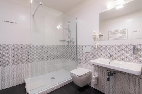 a bathroom with a toilet and a sink and a shower at EA ApartHotel Melantrich in Prague