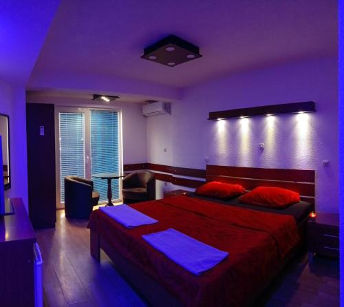 a bedroom with a large bed with a blue lighting at Kice Apartments in Ohrid