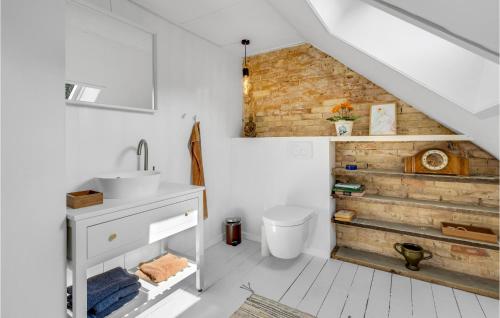 baño con lavabo y pared de madera en Nice Home In Sby r With Wifi en Søby