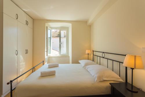 a bedroom with a white bed and white walls at Old City Apartments in Dubrovnik