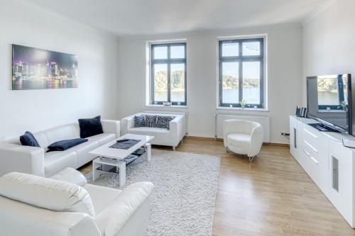a white living room with white furniture and windows at SeaView mit Badesteg in Malchow
