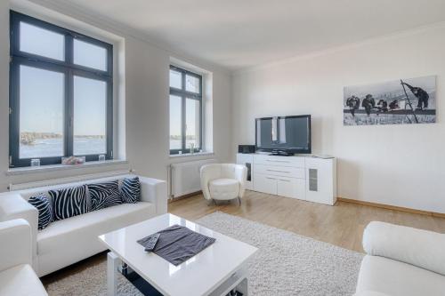 a living room with a white couch and a tv at SeaView mit Badesteg in Malchow