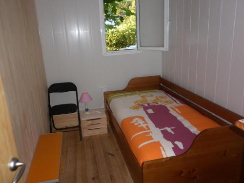 Habitación pequeña con cama y ventana en Cabaña rustica en plena naturaleza en playa de Nerga, Ría de Vigo,, en Hío