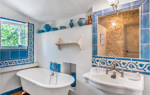 a blue and white bathroom with a tub and a sink at Lovely Home In Lacoste With Kitchen in Lacoste