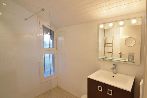 a white bathroom with a sink and a mirror at Tiokers - Hossegor - Confortable villa sur terrain clos idéalement située entre lac et Océan et à 1200m du centre ville in Soorts-Hossegor