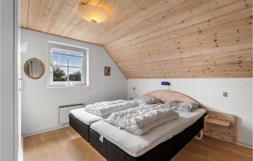 リンケビングにあるBeautiful Home In Ringkbing With 3 Bedrooms, Sauna And Wifiの木製の天井のベッドルーム1室(大型ベッド1台付)