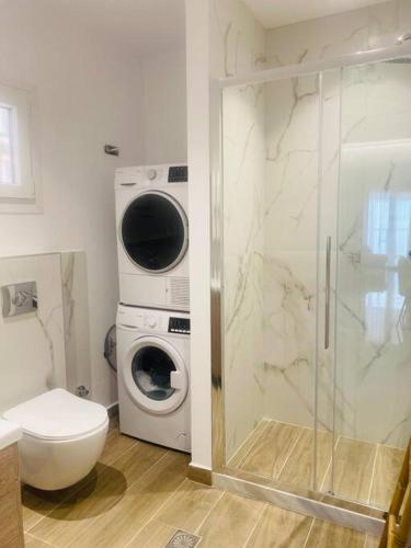 Un baño con inodoro y lavadora. en Ipsos seafront, en Ýpsos