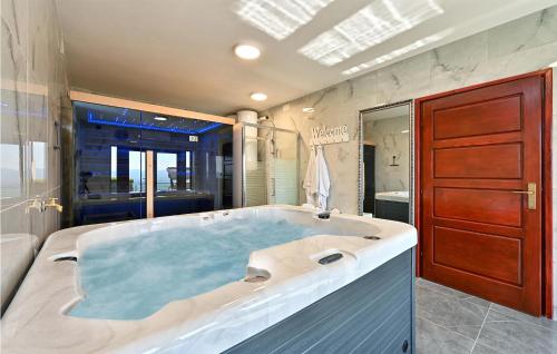 ein großes Badezimmer mit einer großen Badewanne. in der Unterkunft Cozy Home In Madzarevo With Kitchen 