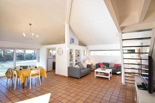 un salon avec une table et un canapé dans l'établissement Tiokers - Hossegor - Confortable villa sur terrain clos idéalement située entre lac et Océan et à 1200m du centre ville, à Soorts-Hossegor