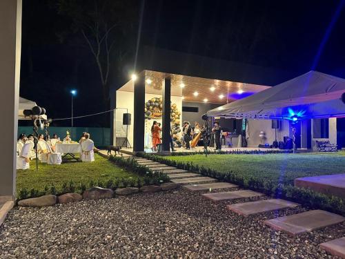 a wedding reception at night with people sitting at tables at Quinta La Bonita Restrepo Meta 