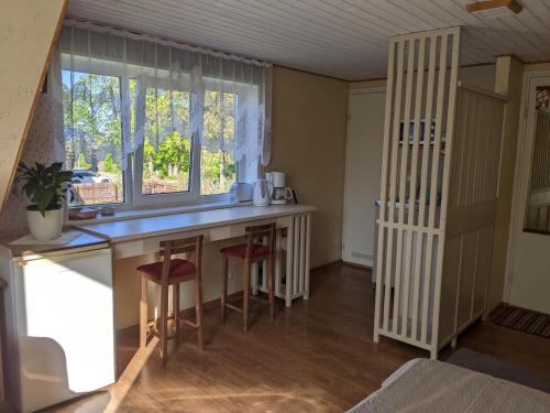 a kitchen with a counter with stools and a window at Apartment Pärna in Kuressaare