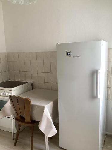 een keuken met een tafel, een stoel en een koelkast bij City-Wohnung 12a in Brühl