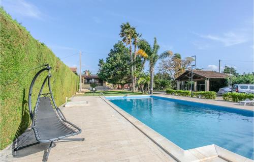 a metal bench next to a swimming pool at Gorgeous Home In Comiso With Wifi in Comiso