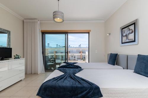 1 Schlafzimmer mit 2 Betten und einem großen Fenster in der Unterkunft Akivillas Albufeira Dawnstar in Olhos de Água