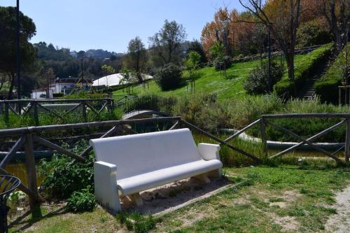 a white bench sitting in the grass next to a fence at Belvedere di Ancona in Ancona