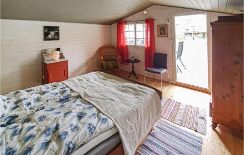 a bedroom with a bed and a chair and a window at Amazing Home In Krager With Wifi And 3 Bedrooms in Kragerø