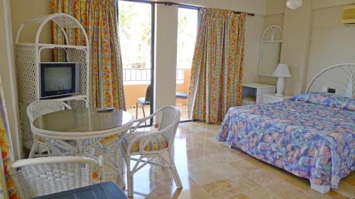 1 dormitorio con 1 cama, mesa y sillas en Residence Meridiana en Juan Dolio