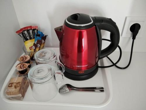 une cafetière rouge assise au-dessus d'un comptoir dans l'établissement Motel Express, à Bogucin