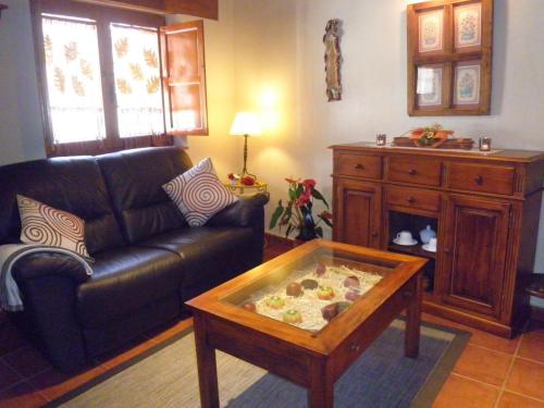 sala de estar con sofá y mesa de centro en El Roble. Azagalla Rural, en Casas del Abad