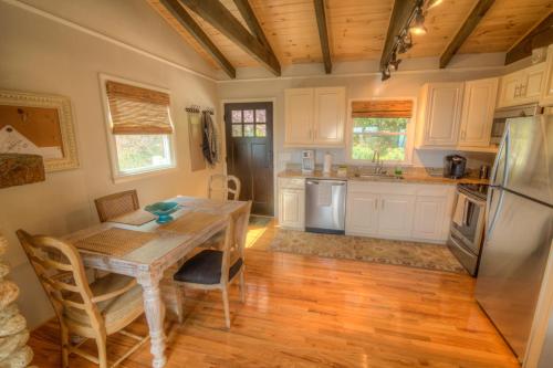a kitchen with a wooden table and a refrigerator at Cloud Forest Lane in Blowing Rock