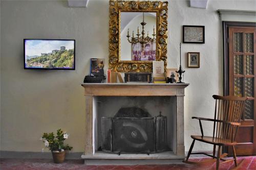 ein Wohnzimmer mit einem Kamin und einem Spiegel in der Unterkunft La casa dei libri in Pontremoli