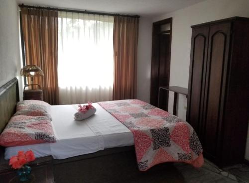 Un dormitorio con una cama con dos muñecas. en Hostería la Gaviota, en Riobamba