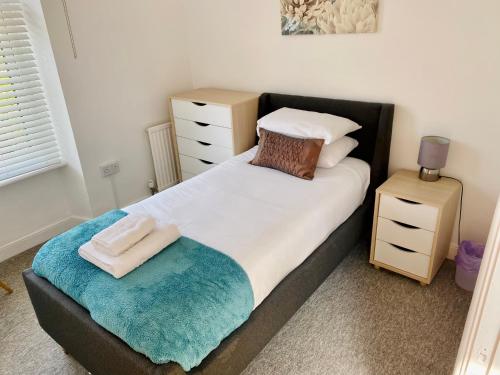 una camera da letto con un grande letto con un cuscino e uno sgabello di Liberty House a Weston-super-Mare