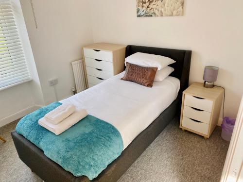 a bedroom with a large bed with a pillow and a stool at Liberty House in Weston-super-Mare