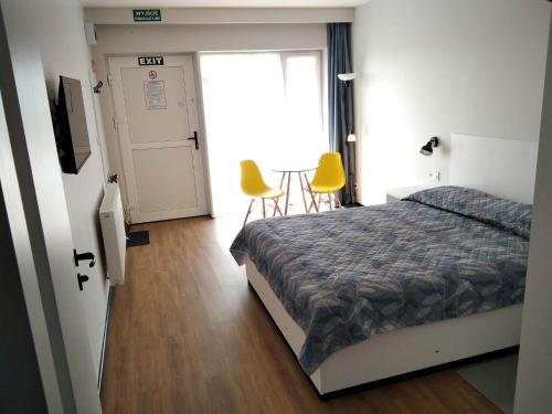 a bedroom with a bed and two yellow chairs at Motel Express in Bogucin