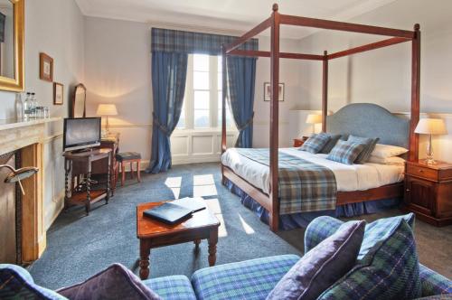 a hotel room with a bed and a couch at Chirnside Hall Hotel in Chirnside