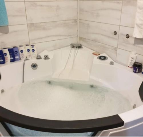 a white bath tub in a bathroom with a toilet at Domaćinska kuća in Arandjelovac