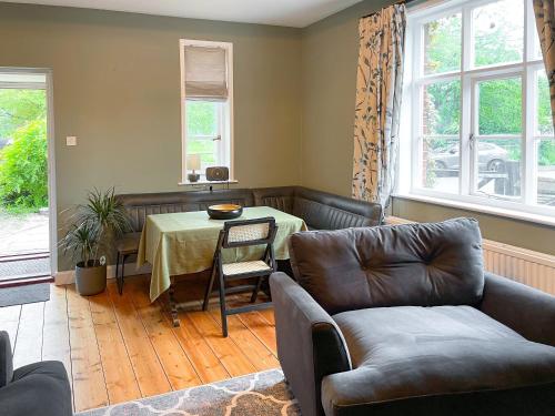 a living room with a couch and a table at Corner Cottage in Alburgh