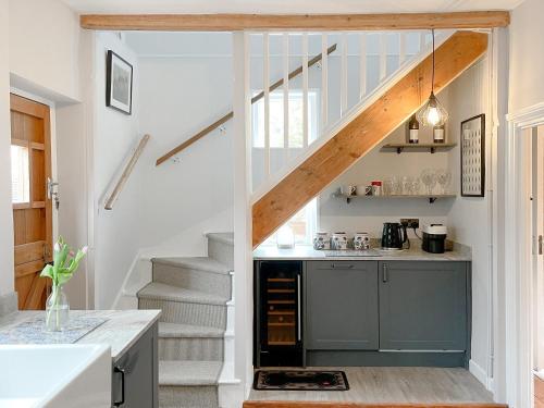 a kitchen with stairs leading up to a loft at Corner Cottage in Alburgh