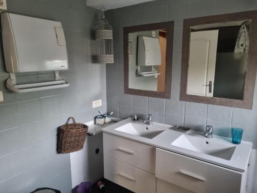 a bathroom with two sinks and two mirrors at Gîte Maison provençale entre Aix et Marseille in Gardanne