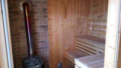 a wooden sauna with a bench and a brick wall at Bommarvikens Bed & Breakfast in Olofström