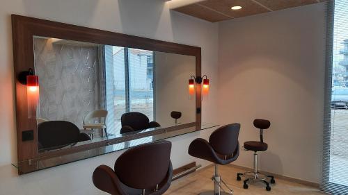 a salon with chairs and a large mirror at Domitys Les Cépages in Gaillac