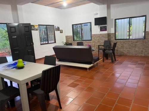 salon ze stołem, krzesłami i telewizorem w obiekcie Hospedaje Campestre Villa Niny w mieście San Gil