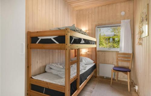 a bunk bed room with two bunk beds and a chair at Stunning Home In Knebel With Sauna, Wifi And Indoor Swimming Pool in Knebel