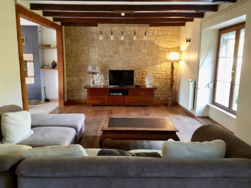 sala de estar con 2 sofás y TV en Chante Ruisseau - Petit Havre de paix Breton, en Plouguenast Langast